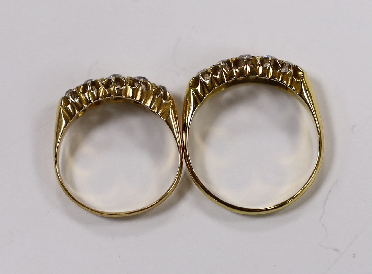 A late Victorian 18ct gold and graduated five stone diamond set half hoop ring, size M/N and an similar Edwardian ring, size R/S, gross weight 6.7 grams.